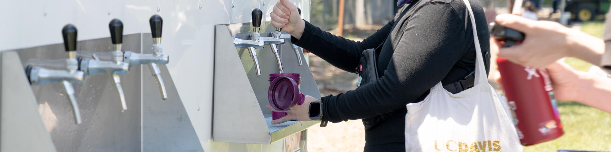 Person refilling their reusable water bottle at a refill station.