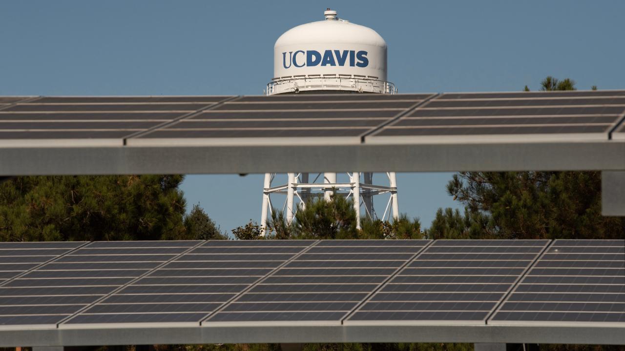 Image of UC Davis watertower in the background with solar panels in the foreground.