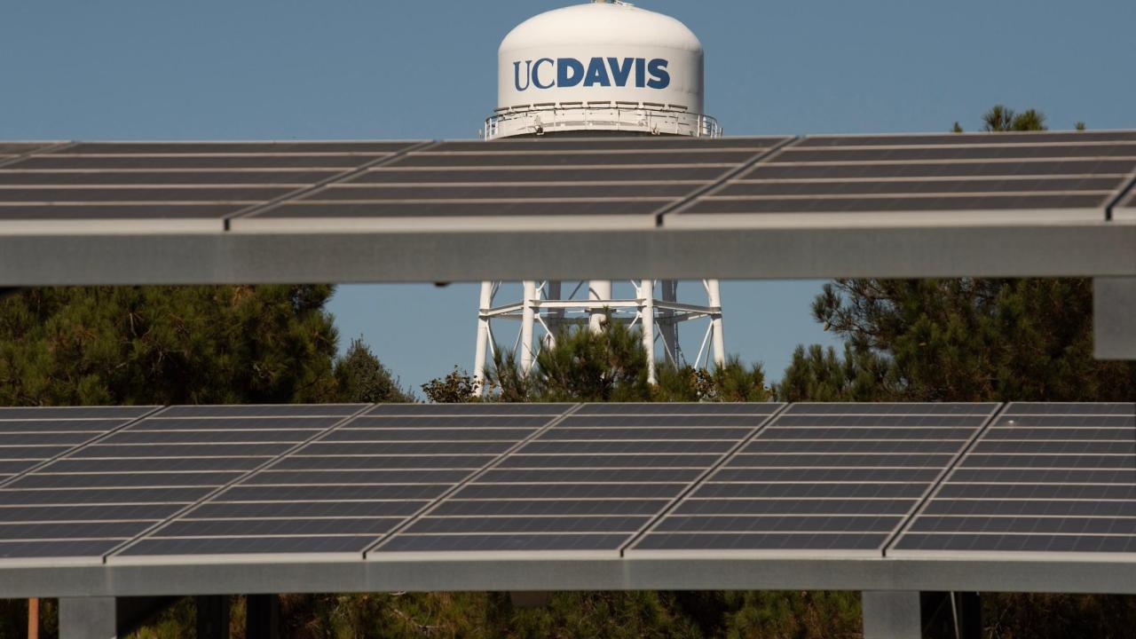 Image of UC Davis watertower in the background with solar panels in the foreground.