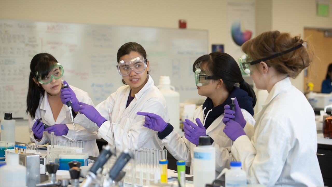 Students in labcoats and goggles