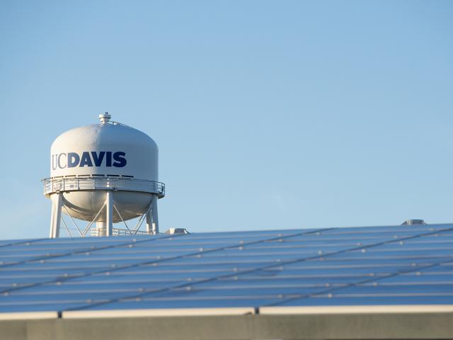 On-site solar panels shade parking spaces at Visitor Parking Lot 1 near the Mondavi Center, with the UC Davis Water Tower behind; January 2020.
