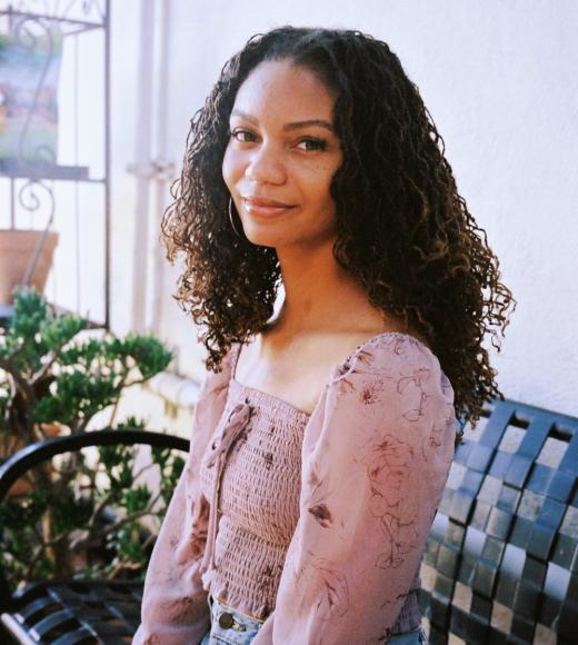 Leah Thomas black woman wearing floral shirt smiling slightly at camera