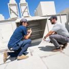 UC Davis staff from the Energy Engineering team examine air flow on top of Ghausi Hall.