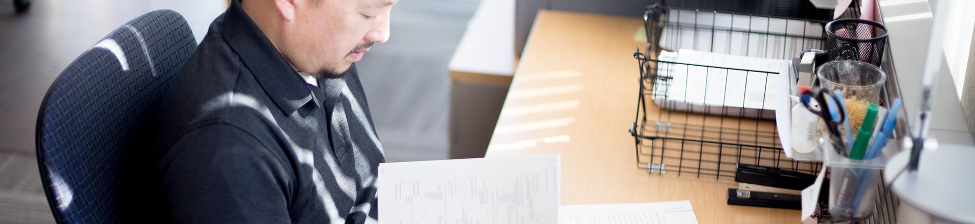uc davis employee at their desk looking at paperwork