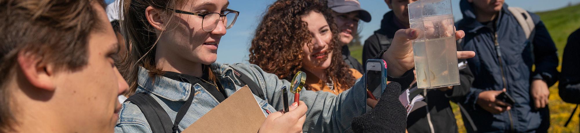 uc davis student studying the clarity of a container of water
